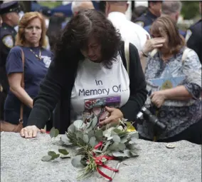  ?? SETH WENIG — THE ASSOCIATED PRESS FILE ?? Tina Tilearcio pauses at a stone that is part of the new 9/ 11 Memorial Glade on the grounds of the National September 11Memorial & Museum, after its dedication ceremony in New York. Her husband, Robert Tilearcio, died in 2017of illness related to his recovery work at ground zero. When nearly 3,000Sept. 11victims’ names are read aloud on the memorial plaza on a half-dozen stacks of stone will quietly salute an untold number of people who aren’t on the list.