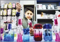  ??  ?? In this April 1, 2016 photo, thirteen-year-old Syrian refugee Ali Rajab, fills bottles of perfume at a shop in Beirut, Lebanon. Rajab is on his feet an average of 12 hours a day, cleaning, filling perfume bottles and helping sell mobile phones at the...