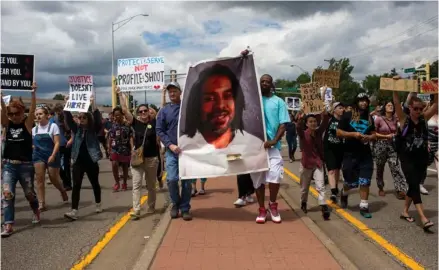  ??  ?? Protesters hold an image Philando Castile and march down the street during a protest, Sunday, June 18, 2017, in St. Anthony, Minn. The protesters marched against the acquittal of Officer Jeronimo Yanez, was found not guilty of manslaught­er for shooting...