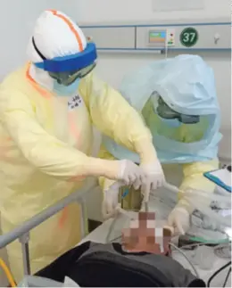  ??  ?? Doctors from the Peking University Third Hospital tend to a patient in Wuhan, Hubei, in February