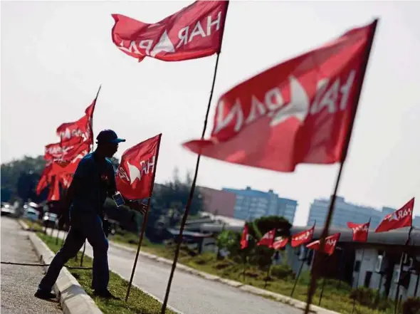  ?? FILE PIC ?? A man planting Pakatan Harapan flags prior to the Port Dickson by-election last year. The new order of New Malaysia can be overturned by the countervai­ling forces of an old regime waiting to pounce on the chance.