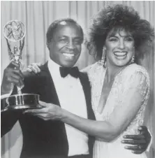  ?? | AP FILES ?? Actor Robert Guillaume, star of “Benson,’’ gets a hug from Linda Gray who presented him with the Emmy for outstandin­g lead actor in a comedy series in 1985.