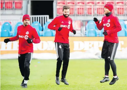  ?? PHOTOS: NATHAN DENETTE/ THE CANADIAN PRESS ?? Toronto FC defender Jason Hernandez, left, defender Drew Moor, centre, and midfielder Michael Bradley get used to the cold at practice on Friday, one day before they host the MLS Cup final against the Seattle Sounders at BMO Field.