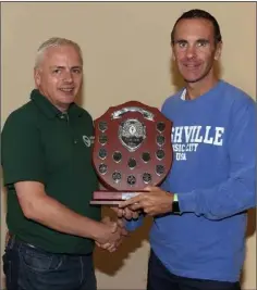  ??  ?? Niall Sheil of St. Killian’s receives his prize after winning the Carrickon-Suir A.C. three-county league.