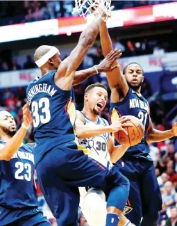  ??  ?? Golden State Warriors guard Stephen Curry (30) goes to the basket between New Orleans Pelicans forward Dante Cunningham (33), forward Anthony Davis (23) and forward Darius Miller (21) during NBA action in New Orleans. (AP)