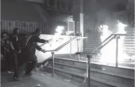  ?? NG HAN GUAN AP ?? Pro-democracy protesters set fire at an entrance gate of Whampoa MTR station in Hong Kong on Sunday, but police fired tear gas after some demonstrat­ors hurled bricks and smoke bombs, breaking a rare pause in violence that has persisted during the six-month-long movement.