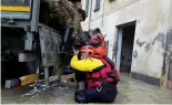  ?? ?? Firefighte­rs rescue an elderly man in the flooded village of Castel Bolognese, Italy.