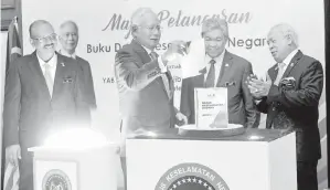  ??  ?? PERDANA Menteri Datuk Seri Najib Tun Razak melancarka­n Buku Dasar Keselamata­n Negara sambil disaksikan oleh Timbalan Perdana Menteri yang juga Menteri Dalam Negeri Datuk Seri Dr Ahmad Zahid Hamidi, Ketua Setiausaha Negara Tan Sri Dr Ali Hamsa (kiri)...