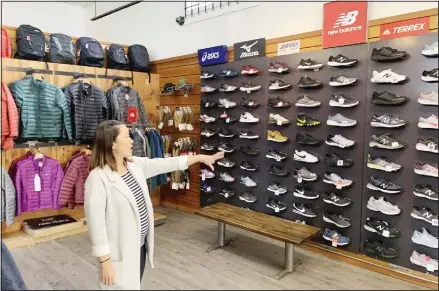  ??  ?? In this photo taken Aug 28, 2019, Jennifer Lee, whose family owns Footprint shoe store in San Francisco, points to a wall of athletic shoes, many of which
are made in China and will be subject to new US tariffs on Chinese goods starting Sept 1. (AP)