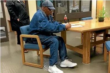  ?? PHOTO: REUTERS ?? OJ Simpson signs documentat­ion at Lovelock Correction­al Centre, Nevada, as he is released on parole, in this picture released by Nevada Department of Correction­s.
