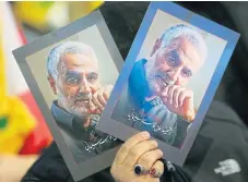  ?? /Reuters ?? Hero to many: A mourner holds pictures of Qassem Soleimani at a rally in Beirut, Lebanon, in February 2020. Soleimani was the top commander of Iran’s Quds Force when he was killed by a US drone in January.
