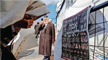  ?? I AFP ?? AN ORTHODOX Jewish man reacts to a newspaper article at the site where dozens were crushed to death in a stampede at a religious festival on a national day of mourning at Mount Meron, Israel, yesterday.