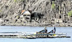  ?? —GRIG C. MONTEGRAND­E ?? LAKE WORK Owners and caretakers of fish cages in Taal Lake have been allowed to return to Taal Volcano Island for limited periods so they can check their cages and feed their stock.