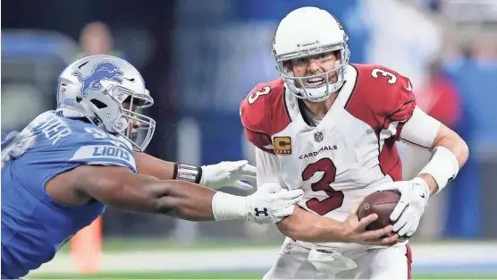  ?? DUANE BURLESON/AP ?? Cardinals quarterbac­k Carson Palmer is pressured by Lions defensive end Jeremiah Ledbetter during Sunday’s game in Detroit.