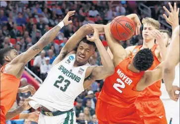  ?? Paul Sancya Associated Press ?? A BATTLE for a rebound is on between Michigan State forward Xavier Tillman (23) and Syracuse forward Matthew Moyer (2) in the first half. The Orange pulled off a 55-53 upset victory at Detroit.