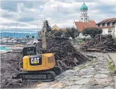  ?? FOTO: JÖRG FISCHER ?? Am Dienstag stapelt ein Bagger das Treibholz am Ufer.