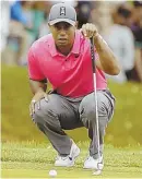  ?? AP PHOTO ?? EYE ON THE BIRDIE: Tiger Woods lines up his putt on the third hole yesterday.