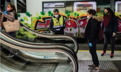  ?? Photograph: Jordi Boixareu/ Zuma/Rex/Shuttersto­ck ?? A security guard controls the distance between commuters on escalators at Catalunya station inBarcelon­a.