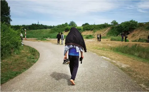  ??  ?? Right Refugees gather on the road by the woods, where many of them live now the Jungle has been dismantled: police regularly destroy their tents