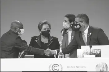  ?? ALBERTO PEZZALI/AP ?? ALOK SHARMA, RIGHT, PRESIDENT OF THE COP26 SUMMIT shakes hands with UNGA President Abdulla Shahid as outgoing COP president Carolina Schmidt, second right, and Patricia Espinosa, UNFCCC Executive-Secretary look on during the Procedural Opening of the COP26 U.N. Climate Summit in Glasgow, Scotland, Sunday.