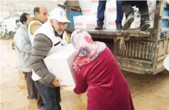  ??  ?? ANKARA: Kuwait Red Crescent Society’s Chairman Dr Hilal Al-Sayer distribute­s relief aid to the Syrian refugees in Turkey. — KUNA
