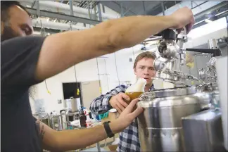  ?? SARAH CRAIG / KQED VIA THE NEW YORK TIMES ?? Charles Denby, a biochemist, pours a mix of brewer’s yeast with molecules from plants that can produce hoppy flavors into a fermentor to make a hop-free beer. Growing the small, green flowers is resource-intensive, and farmers can’t keep up, so Denby...