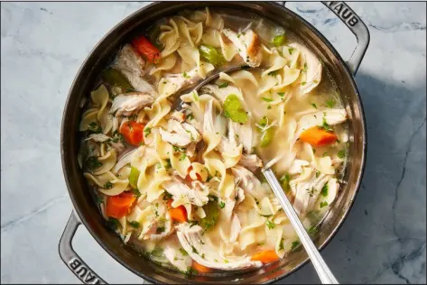  ?? CHRISTOPHE­R TESTANI — THE NEW YORK TIMES ?? With carrots, celery, egg noodles and specks of green herbs, this homemade chicken noodle soup is classic and comforting, but instead of boiling a whole bird for hours, this quick and easy recipe calls for stock and cooked chicken, so it’s doable on a weeknight.