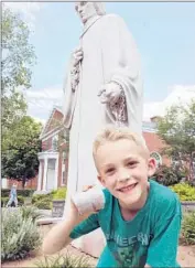  ?? Ryan McCann ?? LIAM McCANN holds a piece of the finger that was broken off West Hartford’s Noah Webster statue.