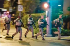  ?? AP PHOTO/JOHN LOCHER ?? Police run toward the scene of a shooting near the Mandalay Bay resort and casino on the Las Vegas Strip in Las Vegas, Oct. 1, 2017. Las Vegas-area fire chief Chief Greg Cassell is calling for changes to Nevada’s emergency response.