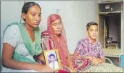  ?? CREDIT / HT PHOTO ?? Gurdip Singh’s daughter (holding his old photo), wife, and son at their house in Jalandhar on Thursday