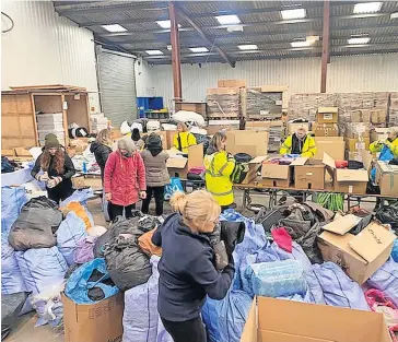  ?? ?? Local generosity Volunteers sort through the donations at the warehouse