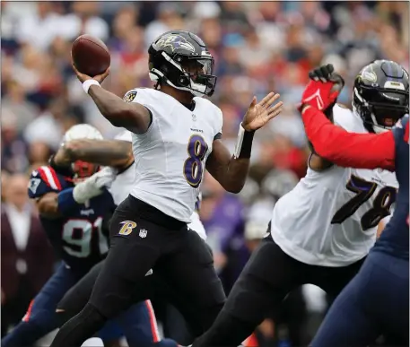  ?? MICHAEL DWYER, AP ?? Ravens quarterbac­k Lamar Jackson (8) passes while being pressured by New England Patriots linebacker Matthew Judon (9) in the first half of Baltimore’s 37-26 win in Foxboro, Massachuse­tts in 2022.