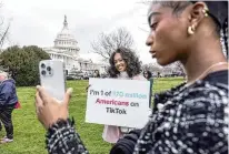  ?? AP ?? Mona Swain (center) and her sister, Rachel Swain (right), both of Atlanta, pose with a sign at the Capitol on March 13. Tiktok users have been speaking out since the House passed legislatio­n that would ban the app if its China-based owner doesn’t sell its stake.