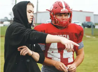  ?? STAFF PHOTOS BY C.B. SCHMELTER ?? Daniel O’steen, left, talks with James Beddington during football practice Tuesday at Lakeview-Fort Oglethorpe High School. O’steen, who gave up football after two major knee surgeries, has taken on a student coaching role.