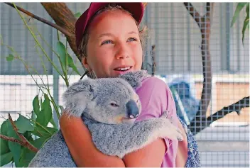  ?? FOTO: NETFLIX/DPA ?? Izzy Bee hält einen ihrer Koalas im Arm. Sie ist eine Koala-Flüsterin und verbringt den Großteil des Tages mit den putzigen Beuteltier­en in der Tierklinik ihrer Eltern. Nun hat Netflix dem Mädchen eine eigene Serie gewidmet.