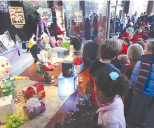  ?? STAFF PHOTOS BY ERIN O. SMITH ?? Kids check out the holiday window display during EPB’s revealing event on Wednesday. The EPB Holiday Windows will remain on display through January 1.