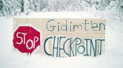  ?? THE CANADIAN PRESS ?? A sign marks a blockade checkpoint by the Gidimt’en clan of the Wet’suwet’en First Nation. Supporters of an Indigenous camp blocking access to a planned pipeline in northern British Columbia say they are anticipati­ng RCMP action over an injunction filed against them.