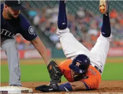  ?? Associated Press ?? Houston Astros' Carlos Correa, right, is tagged out by Seattle Mariners first baseman Yonder Alonso on a pickoff play during the third inning of a baseball game Friday in Houston.