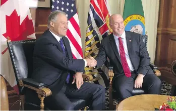  ?? DIRK MEISSNER/THE CANADIAN PRESS ?? Washington Gov. Jay Inslee shakes hands with Premier John Horgan at the legislatur­e in Victoria on Tuesday. Inslee says he’s “bullish” about high-speed rail linking his state and B.C.