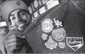  ??  ?? ABRAHAM CASTILLO shows patches on his jacket that signify trips to various cities by Pantone 294.