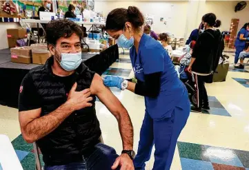  ?? Photos by Marvin Pfeiffer / Staff photograph­er ?? Erwin Richter, 49, smiles under his mask after receiving his first COVID-19 shot from Clara Del Bosque of St. Philip’s College at Wellmed’s Elvira Cisneros Senior Community Center on Southwest Military Drive.