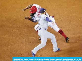  ?? — AFP ?? WASHINGTON: Justin Turner #10 of the Los Angeles Dodgers picks off Howie Kendrick #47 of the Washington Nationals in a run down during the seventh inning of Game 3 of the NLDS at Nationals Park in Washington.