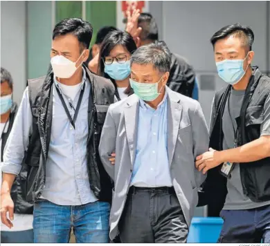  ?? JEROME FAVRE / EFE ?? El director de operacione­s de ‘Apple Daily’, Royston Chow tat-kuen (c), es escoltado por agentes tras su arresto.
