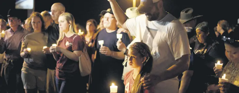  ??  ?? People attend a candle light vigil after a mass shooting at the First Baptist Church in Sutherland Springs, Texas, Nov. 5.