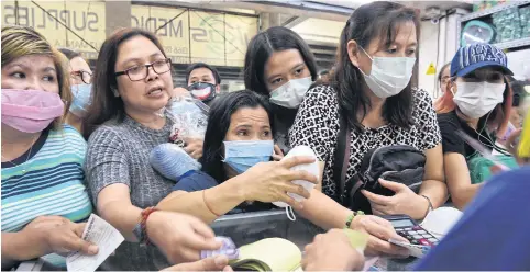  ?? AFP ?? People are pictured buying protective masks at a medical supplies store in Manila last week. The Philippine­s reported yesterday that a 44-year-old Chinese man from Wuhan had died in the country.