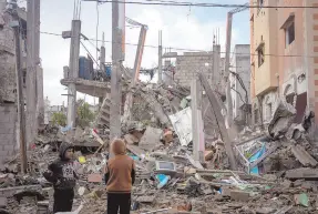  ?? ?? l Palestinos observan la destrucció­n después de un ataque israelí en Rafah, en el Sur de la Franja de Gaza, ayer.