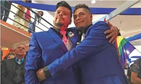 ??  ?? Vestidos de azul metálico, los novios no paraban de dar entrevista­s mientras eran felicitado­s por familiares y amigos que asistieron a ver su enlace matrimonia­l.