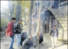  ?? HT PHOTO ?? Migrant workers huddle around a fire in Anantnag.