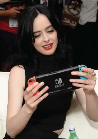  ?? MICHAEL KOVAC/GETTY IMAGES FOR NINTENDO ?? Actress Krysten Ritter checks out Nintendo Switch during Comic-Con Internatio­nal last week in San Diego.