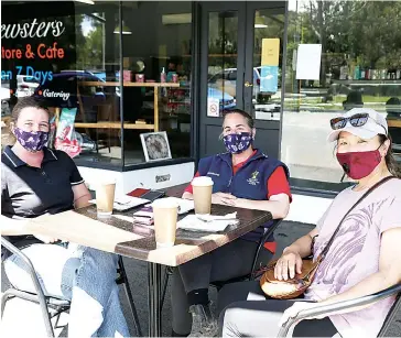  ??  ?? Friends Karen Marshall, Amanda Berg and Ayumi Stokes enjoy coffee together in Garfield for the first time since July..